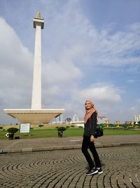 Woman standing against cloudy sky