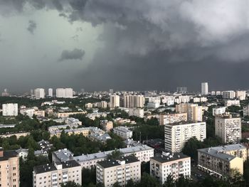 Buildings in city against cloudy sky