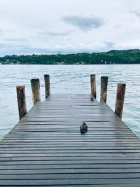 Wooden pier over lake against sky