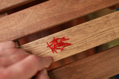 Close-up of hand holding paper on table