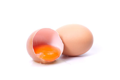 Close-up of broken egg against white background