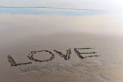 High angle view of text on sand at beach