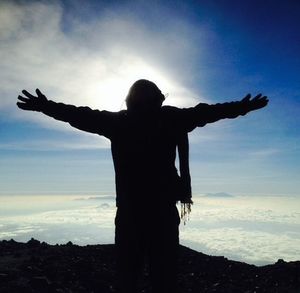 Rear view of silhouette man standing against sky