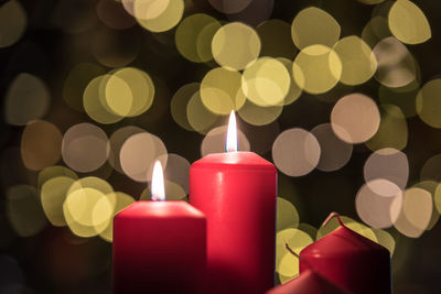 Close-up of illuminated candles against christmas lights