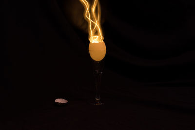 Close-up of light bulb over black background