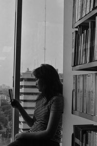 Side view of senior woman reading book at library