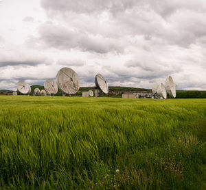 Hay bales on field against sky