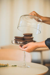 Cropped hand of man holding wineglass on table