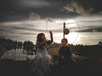 Two children playing in the evening against the background of the sunset