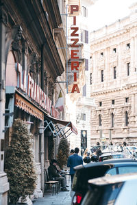 People on street amidst buildings in city
