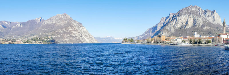 Panoramic view of sea and mountains against clear blue sky