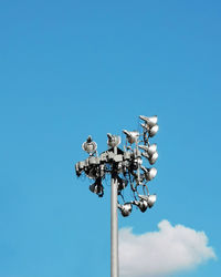 Low angle view of floodlight against blue sky