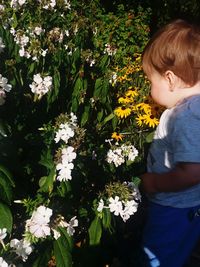 Full length of boy on flowering plant