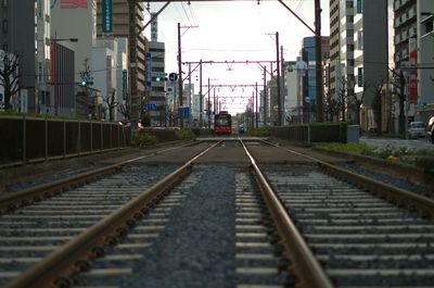 Railroad tracks in city against sky