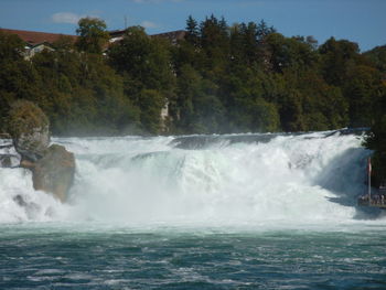 Scenic view of waterfall against sky