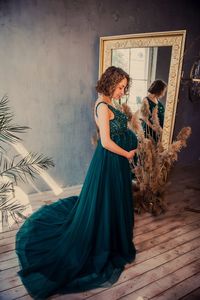 Full length of pregnant woman standing in front of mirror