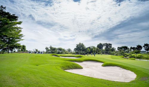 Scenic view of golf course against sky