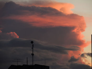 Low angle view of silhouette building against dramatic sky