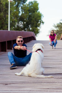 Man sitting with dog on footbridge