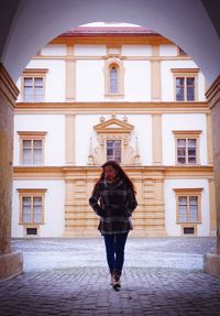 Full length of woman walking against building