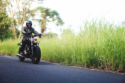 Man riding motor scooter on road