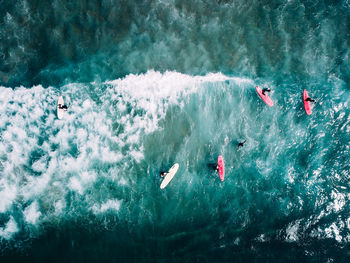 Aerial view of people surfing in sea