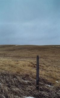 Scenic view of field against cloudy sky