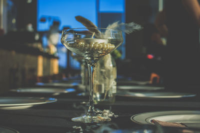 Close-up candle and necklace in wineglass on table