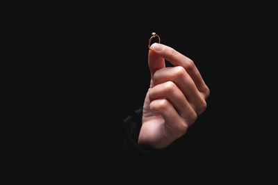 Close-up of human hand against black background