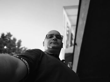 Portrait of young man wearing sunglasses standing outdoors