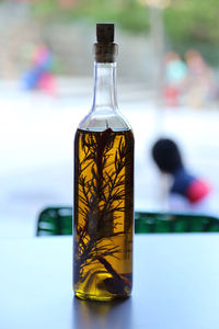 Close-up of rosemary olive oil in bottle on table