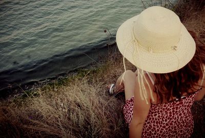 Rear view of woman standing by sea