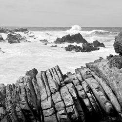 Rocks by sea against sky