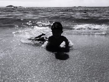 Boy lying on front at beach