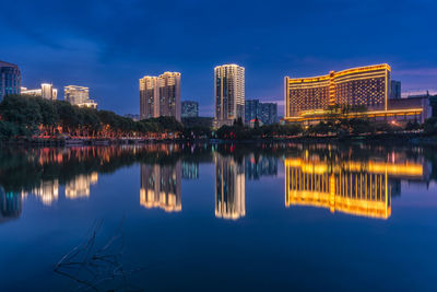 Reflection of buildings in lake at night