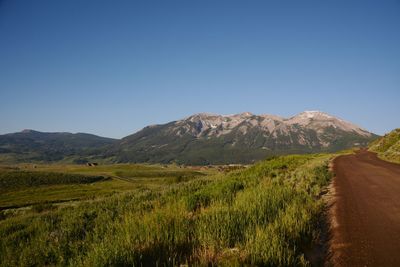 Scenic view of mountains against clear blue sky