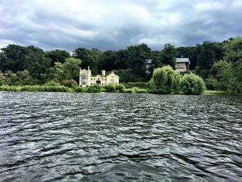 Scenic view of river against cloudy sky