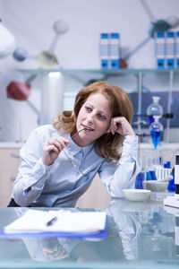 Portrait of female doctor examining chemical in laboratory