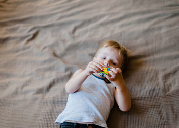 High angle view of baby lying on bed at home