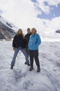 Portrait of woman with kids standing at athabasca glacier in jasper national park against sky