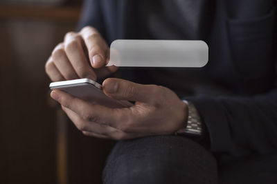 Midsection of man using mobile phone