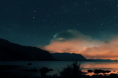 Scenic view of mountains against sky at night