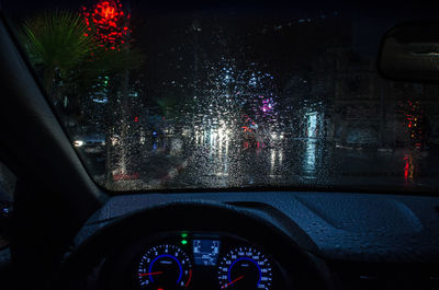 Illuminated building seen through wet glass