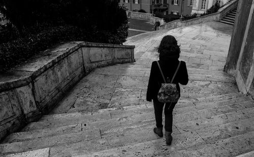 Rear view of woman walking on footpath