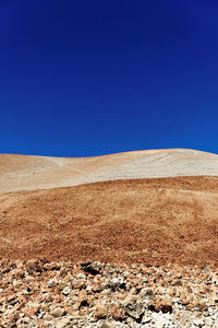 Scenic view of desert against clear blue sky