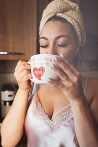 Woman with eyes closed having drink