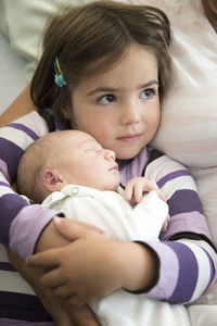 Cute girl with brother lying down on bed