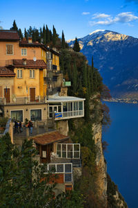 Buildings by sea against sky