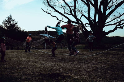 People playing on field against sky