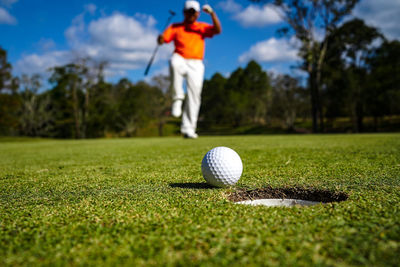 Low section of woman playing golf on field